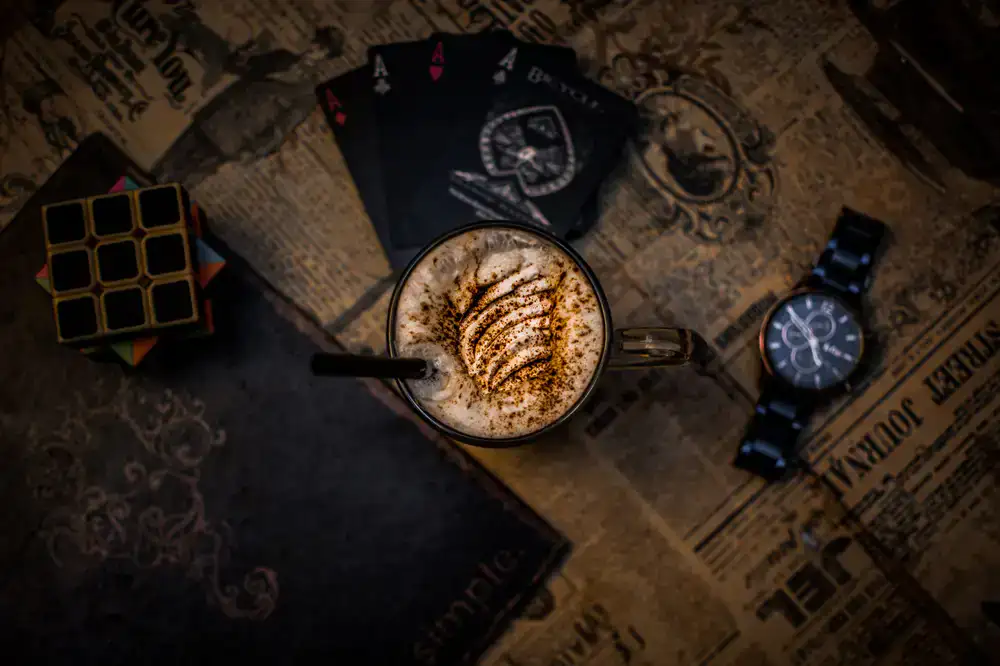 A latte next to a partially completed puzzle